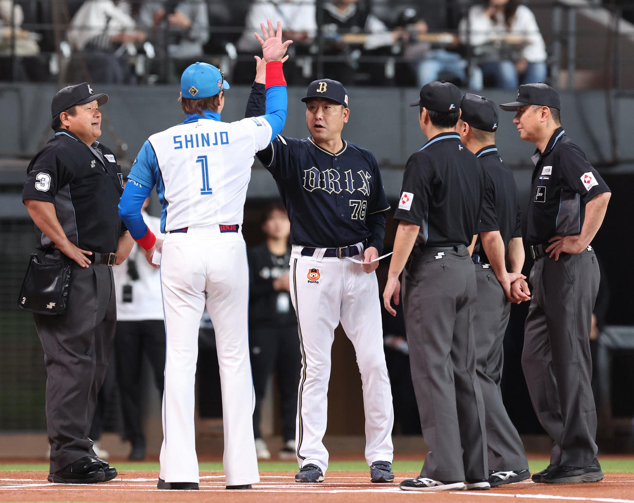 日本ハム対オリックス　試合前、メンバー表を交換し手の甲を見せ合う日本ハム新庄監督（左手前）と中嶋監督（撮影・佐藤翔太）