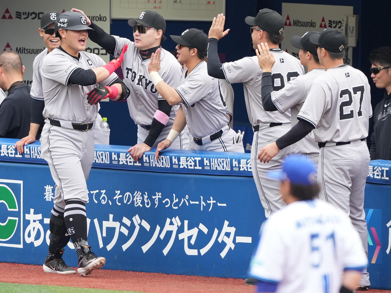 DeNA対巨人　2回表巨人無死、先制の左越えソロ本塁打を放った岡本和はナインと笑顔でハイタッチ（撮影・鈴木みどり）