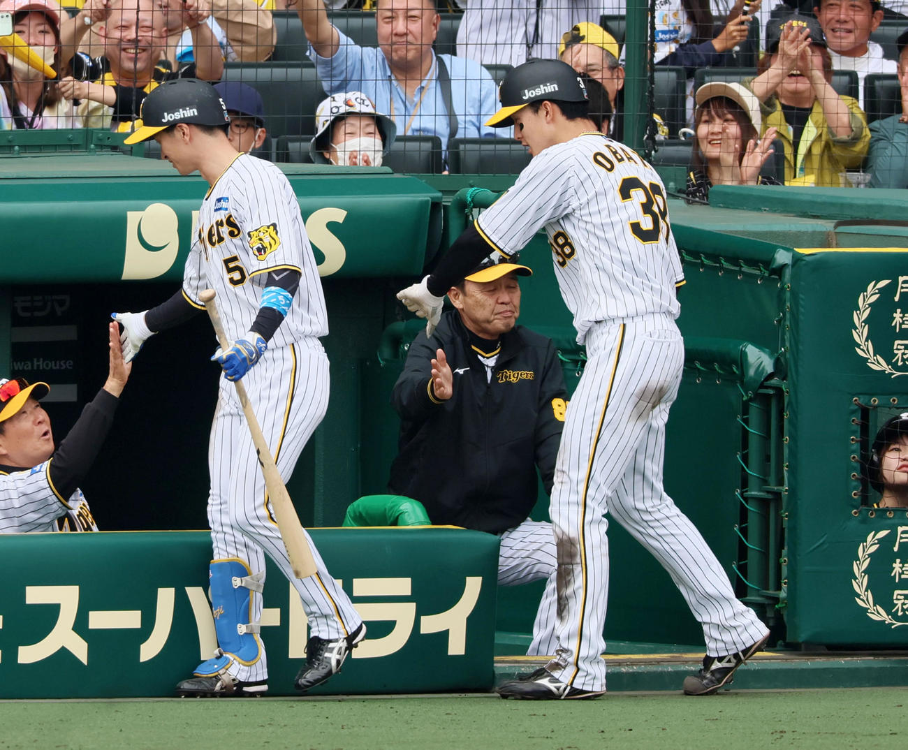 阪神対ヤクルト　5回裏阪神1死二塁、近本（左）の右越えソロ本塁打で生還した二塁走者小幡はベンチの岡田監督とタッチ（撮影・加藤哉）