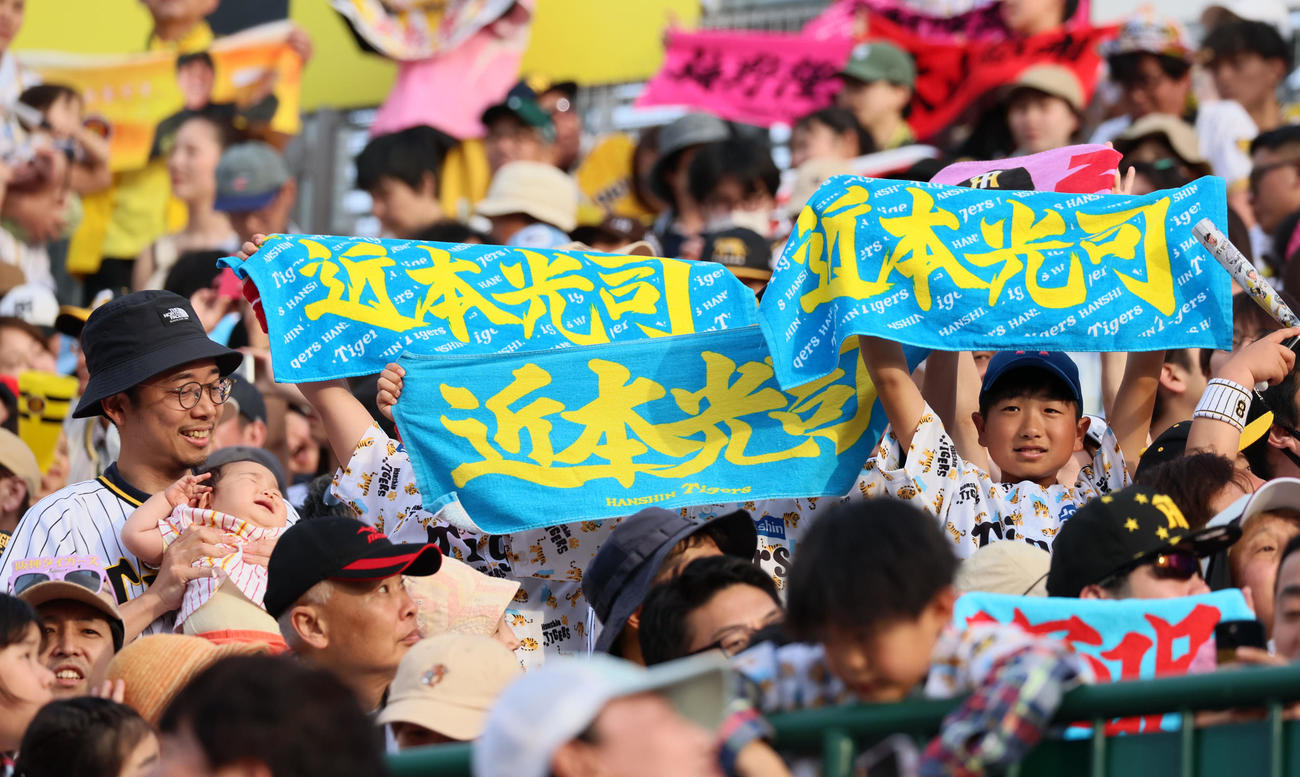 阪神対ヤクルト　ヤクルトに勝利しお気に入りの選手タオルを広げて笑顔を見せる阪神ファンの子供たち（撮影・加藤哉）