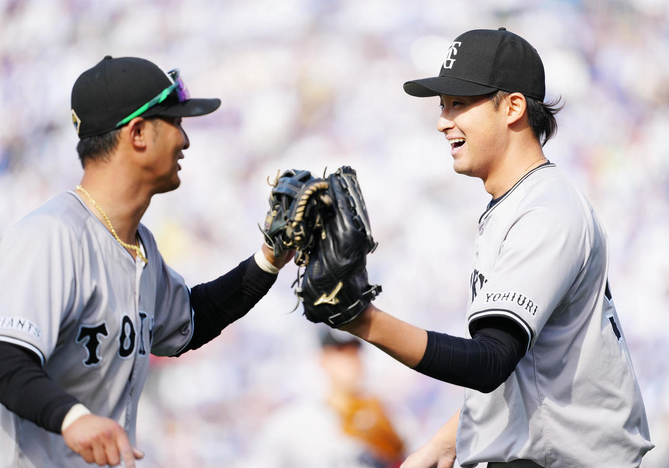 DeNA対巨人　5回裏終了後、巨人吉川（左）とタッチを交わす2番手の堀田（撮影・江口和貴）