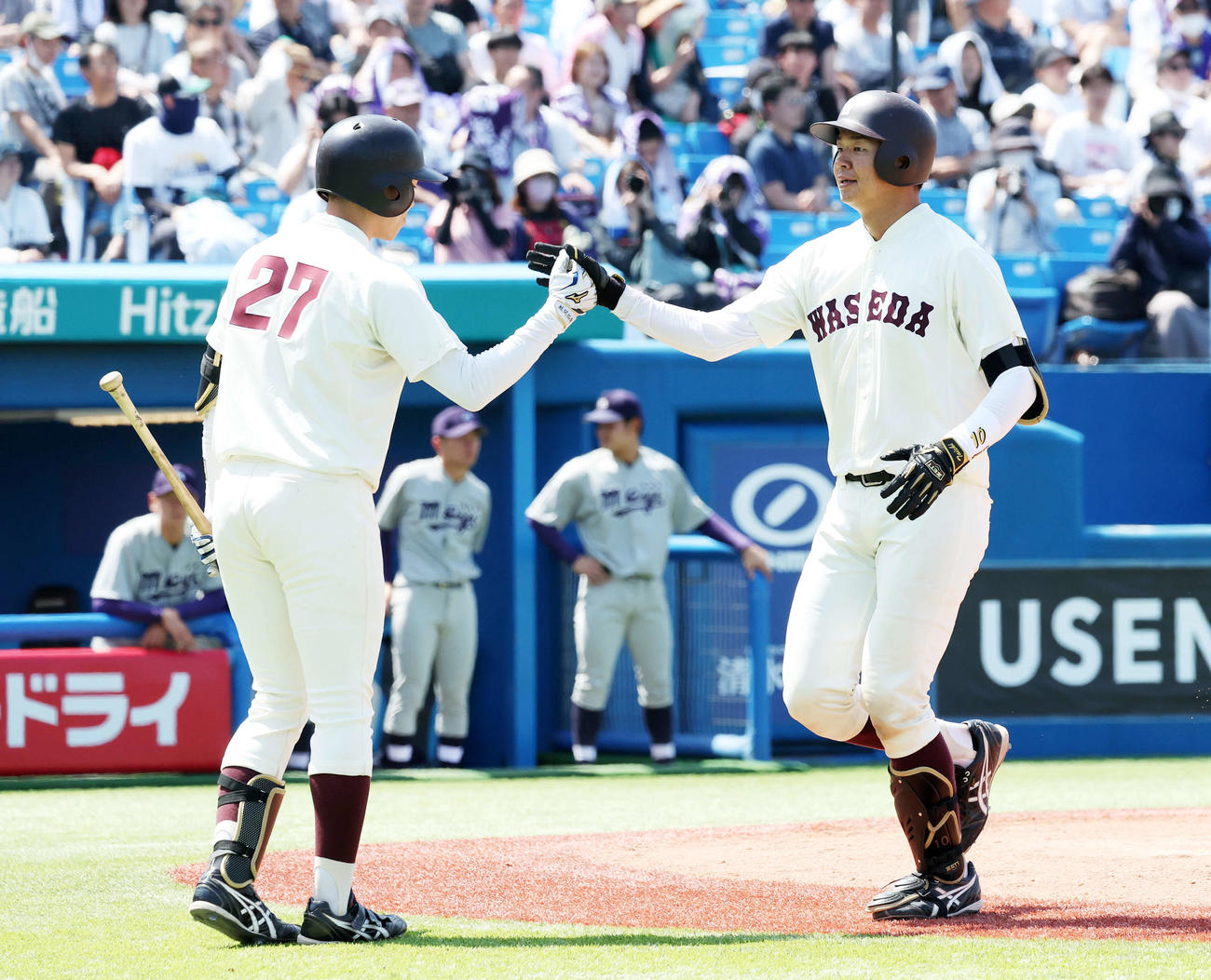 明大対早大　9回裏早大無死一塁、印出（右）は左越え2点本塁打を放ち吉田とタッチ（撮影・鈴木正人）
