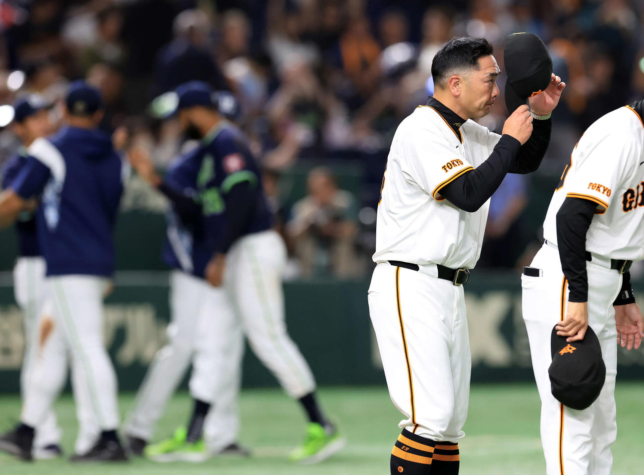 巨人対ヤクルト　完封負けを喫し、喜ぶヤクルトの選手たちを背に脱帽してあいさつする巨人阿部監督（撮影・浅見桂子）
