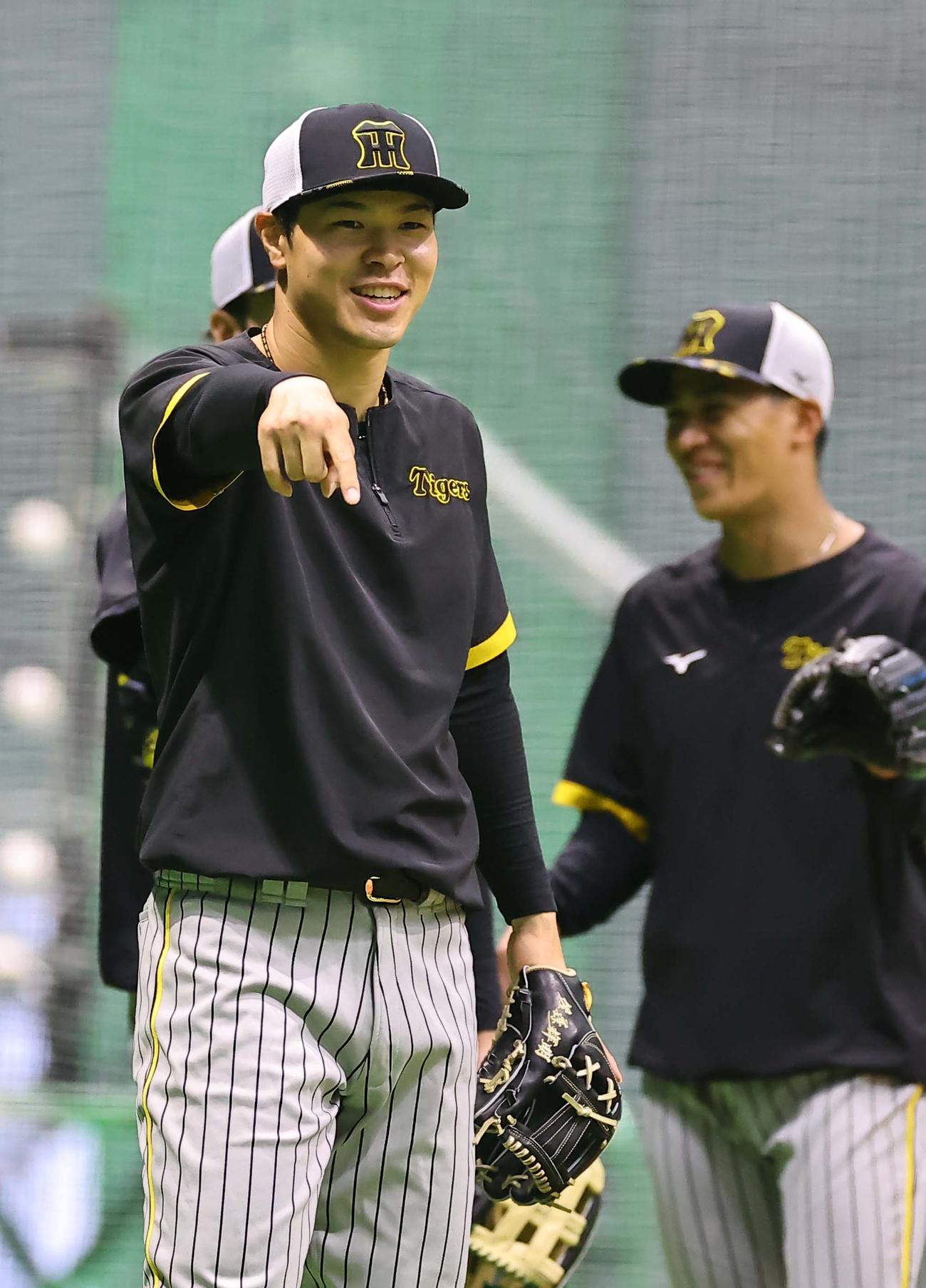 笑顔を見せながらノックを受ける佐藤輝（撮影・上田博志）