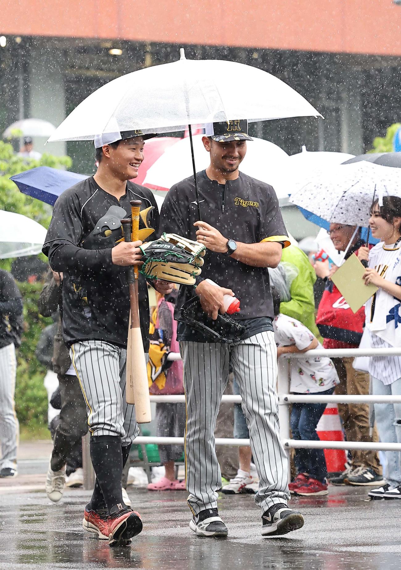 広島対阪神　ゲラ（右）に傘を差してもらい仲良く移動する森下（撮影・上田博志）