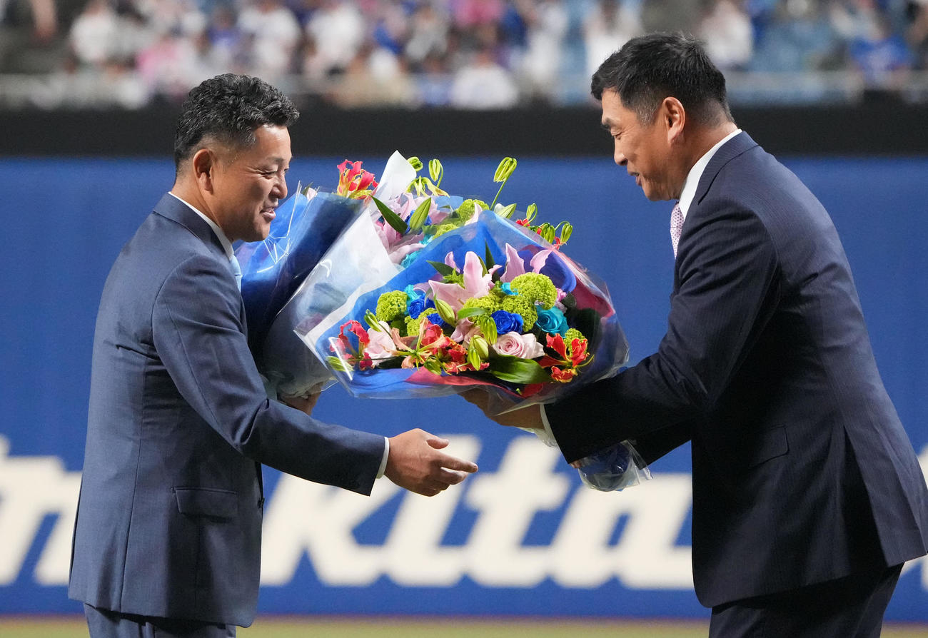 中日対DeNA　試合前に行われた野球殿堂入りセレモニーで山本昌氏から花束を受け取る谷繁元信氏（左）（撮影・森本幸一）