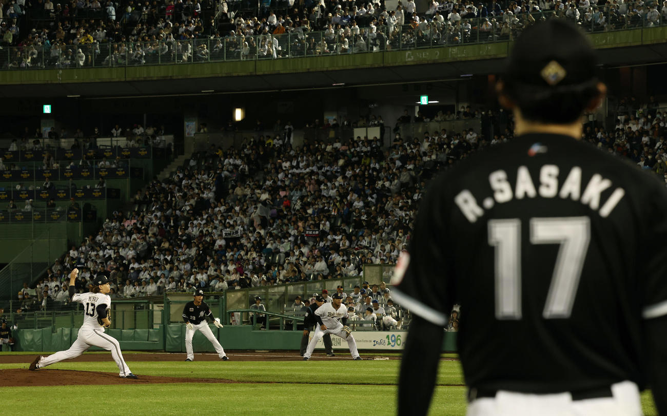 オリックス対ロッテ　3回表、ロッテ佐々木（手前）が見つめる前で力投するオリックス宮城（左）（撮影・前田充）
