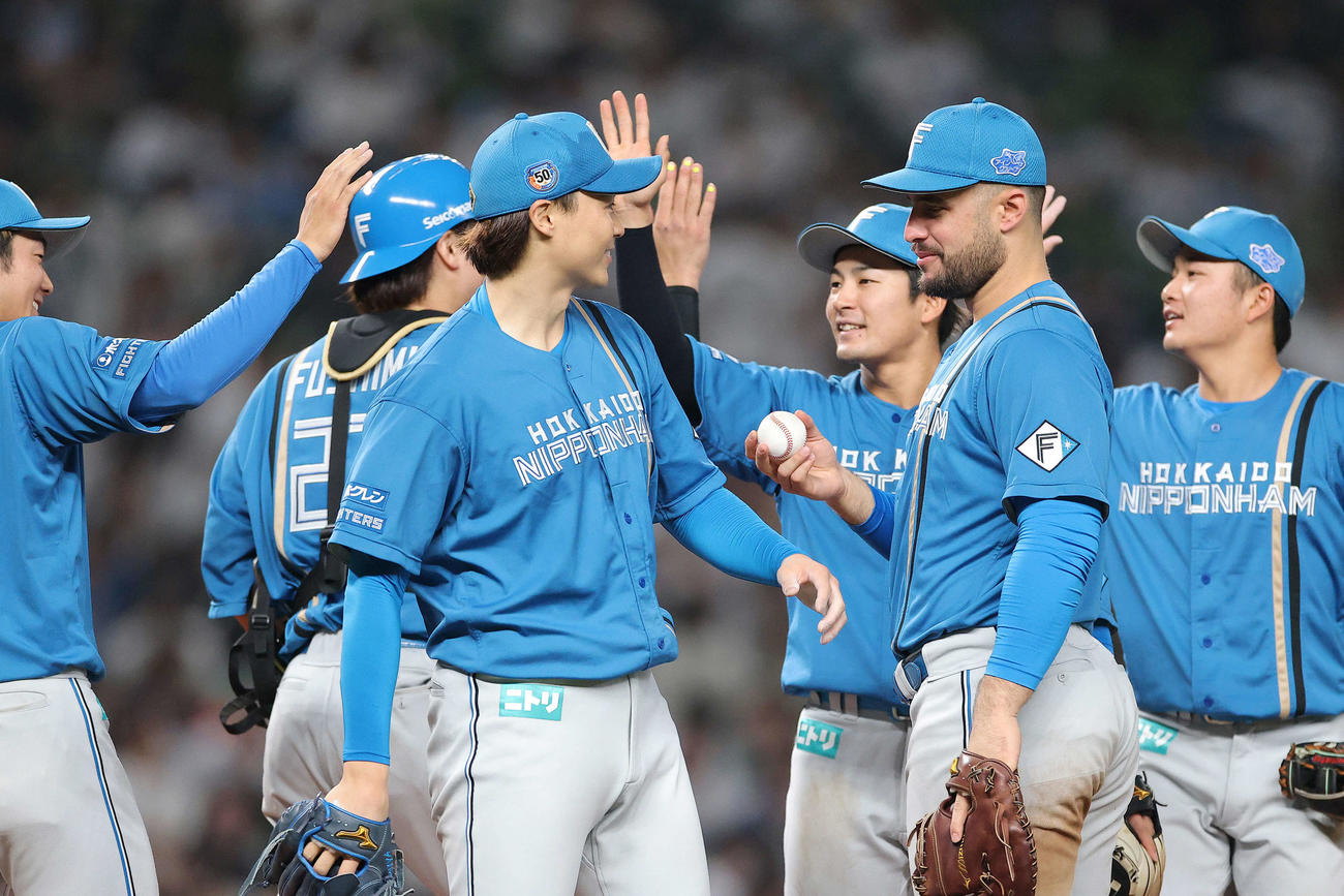 西武対日本ハム　西武に完投勝利し、マルティネス（手前右）からウイニングボールを受け取る日本ハム山崎（撮影・河田真司）