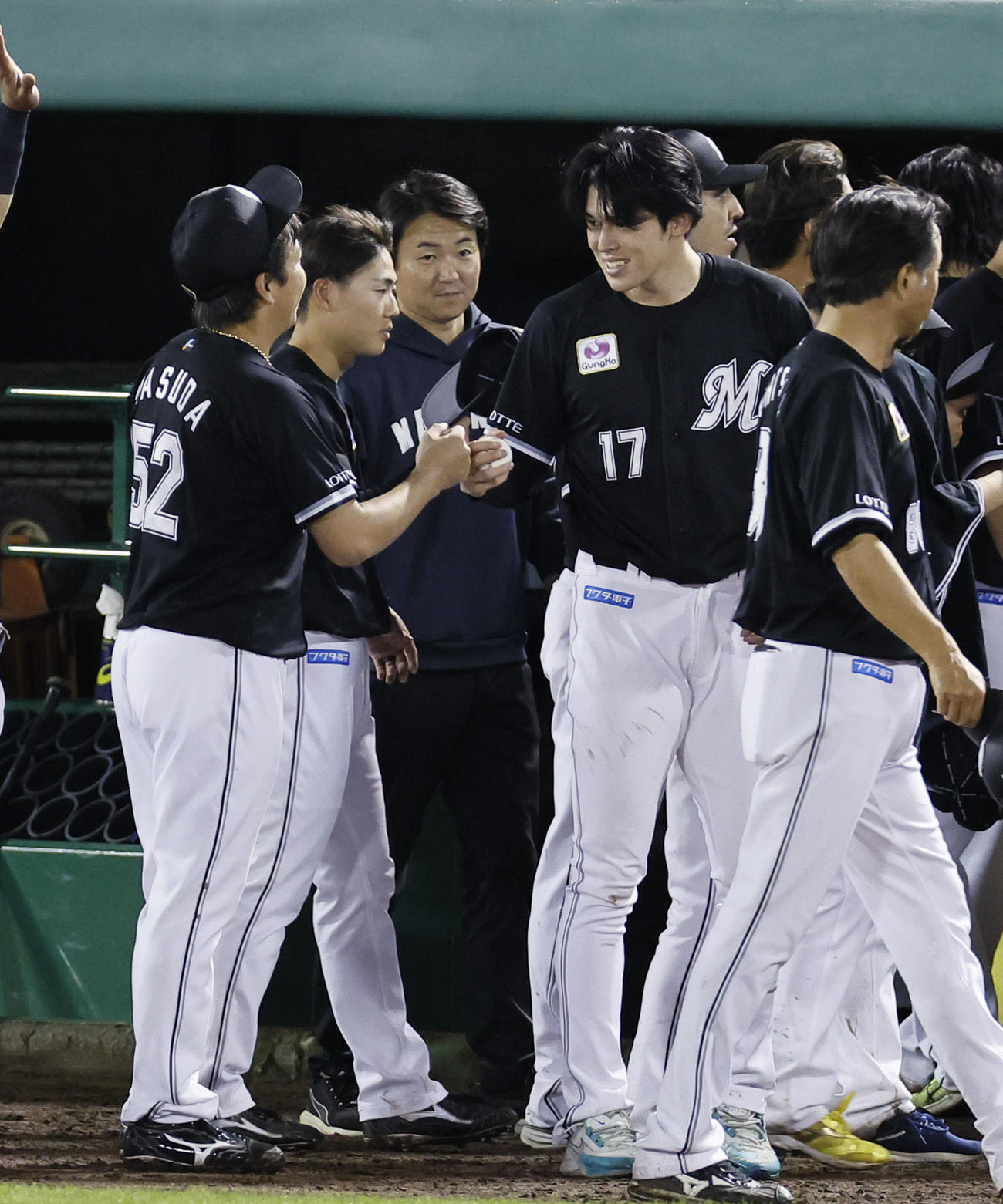 オリックス対ロッテ　最後を締めた益田（左端）から勝利球を受け取り、グータッチを交わすロッテ佐々木（撮影・藤尾明華）