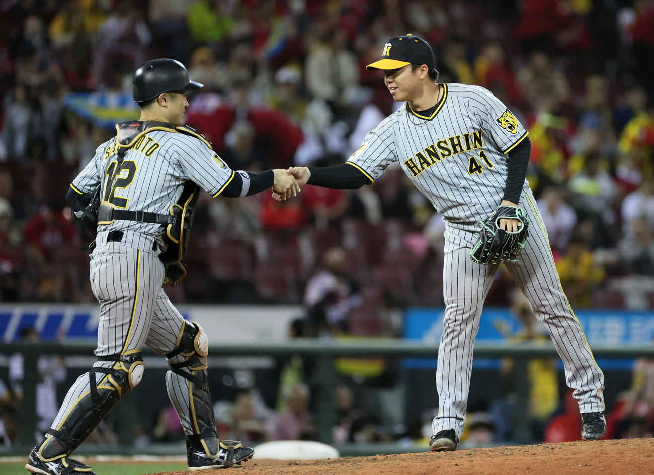 広島対阪神　完投勝利を挙げた村上（右）は坂本と握手を交わす（撮影・加藤孝規）
