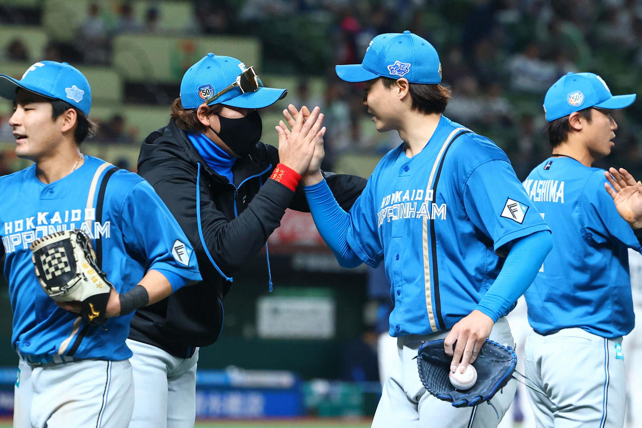 西武対日本ハム　西武に勝利し山崎（右から2人目）らナインを迎える日本ハム新庄監督（撮影・河田真司）