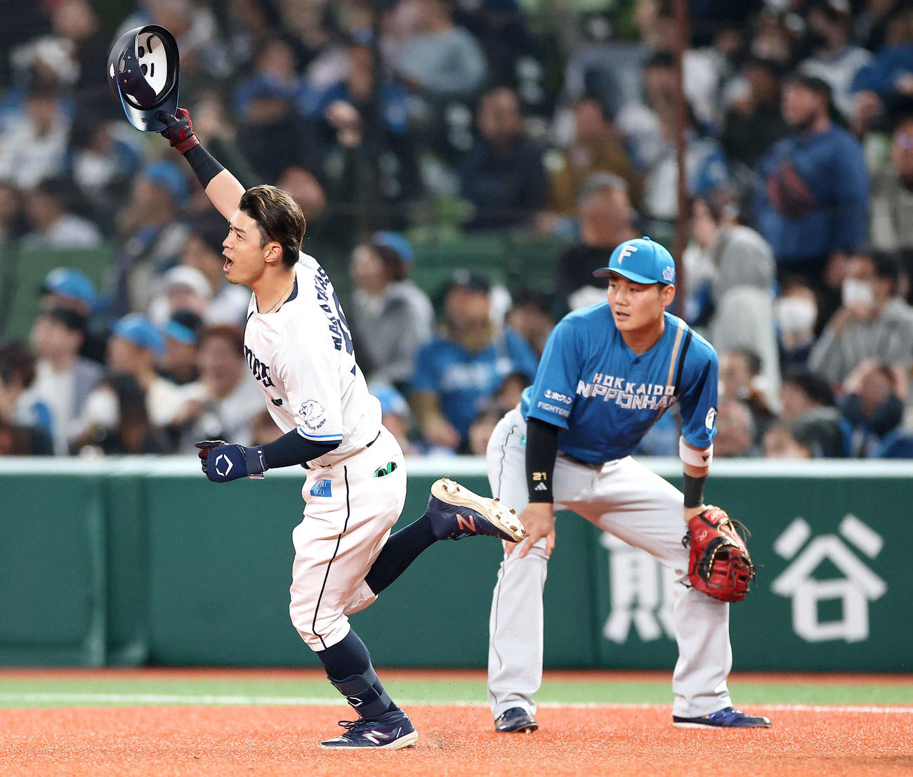 西武対日本ハム　9回裏西武2死二塁、左越えサヨナラ2点本塁打を放ち、ヘルメットを掲げる若林（左）。右は一塁手清宮（撮影・河田真司）
