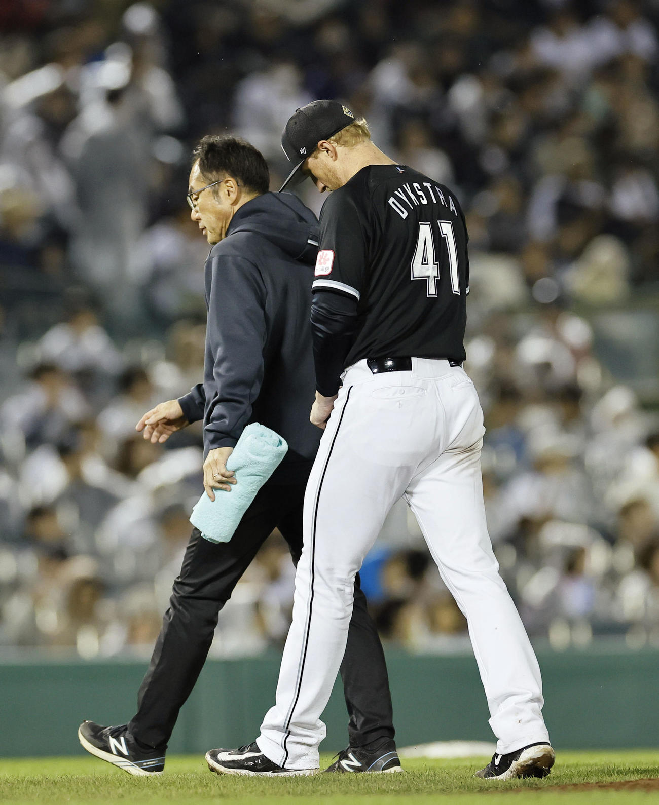 オリックス対ロッテ　5回裏のマウンドに上がるも、治療のためベンチに戻るロッテのダイクストラ（右）。そのまま降板した（撮影・藤尾明華）