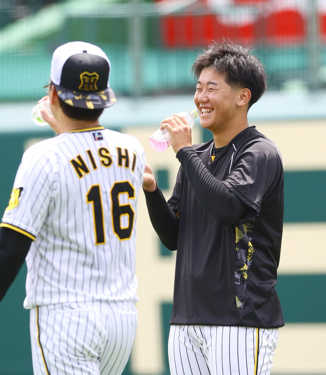 リラックスした表情で阪神西勇（手前）と話す阪神門別（撮影・上山淳一）