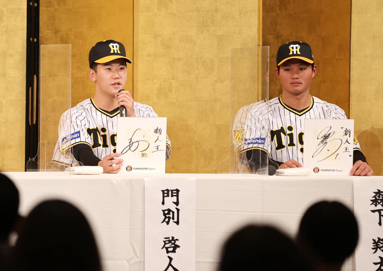 色紙に目標を書いて話すドラフト2位の門別（左）とドラフト1位の森下（2022年12月12日）