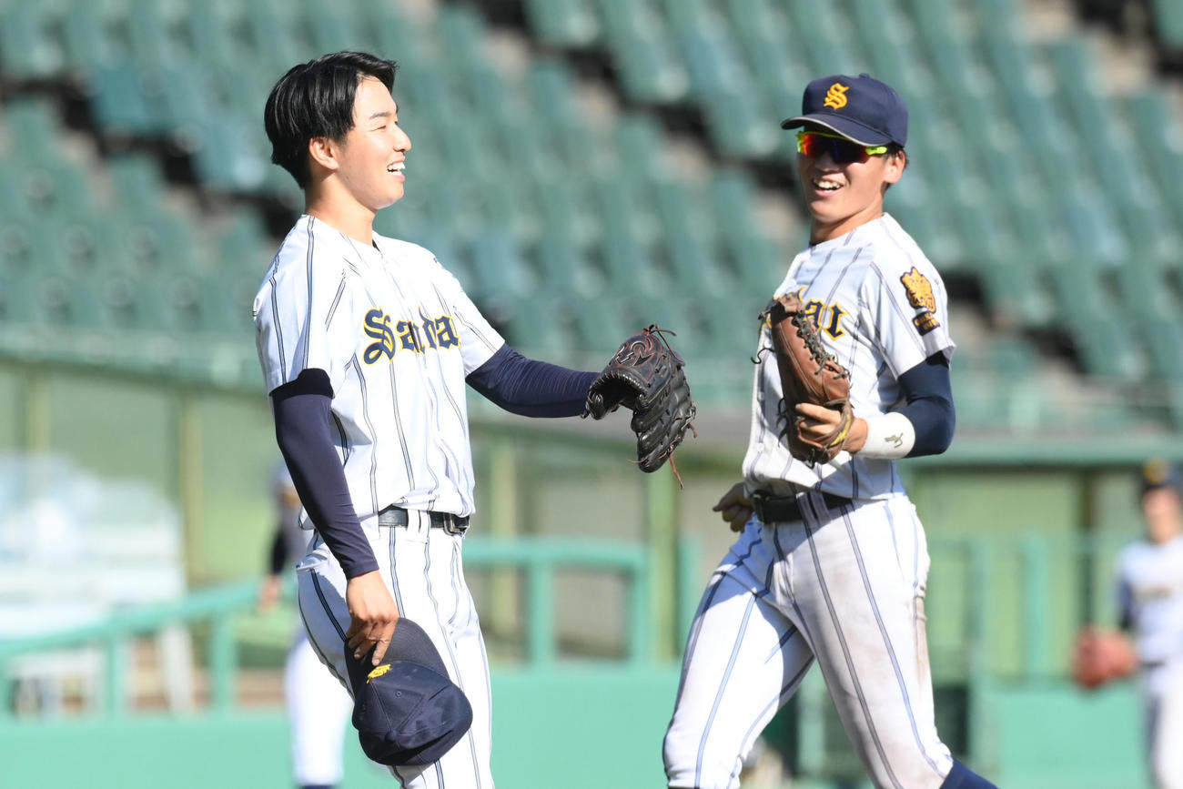 大産大対天理大　　大学初の完投勝利をあげた大産大の長友（左）は、仲間とハイタッチ（撮影・滝沢美穂子）