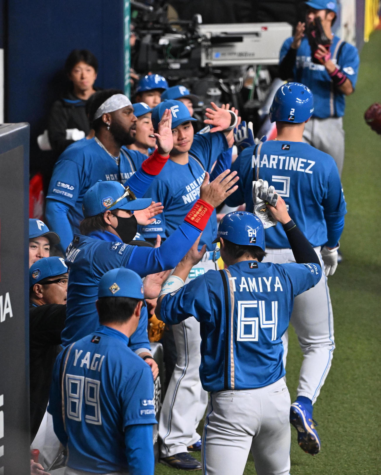 オリックス対日本ハム　1回表日本ハム2死一、二塁、万波の適時二塁打で生還したマルティネス、田宮を迎える新庄監督（撮影・和賀正仁）