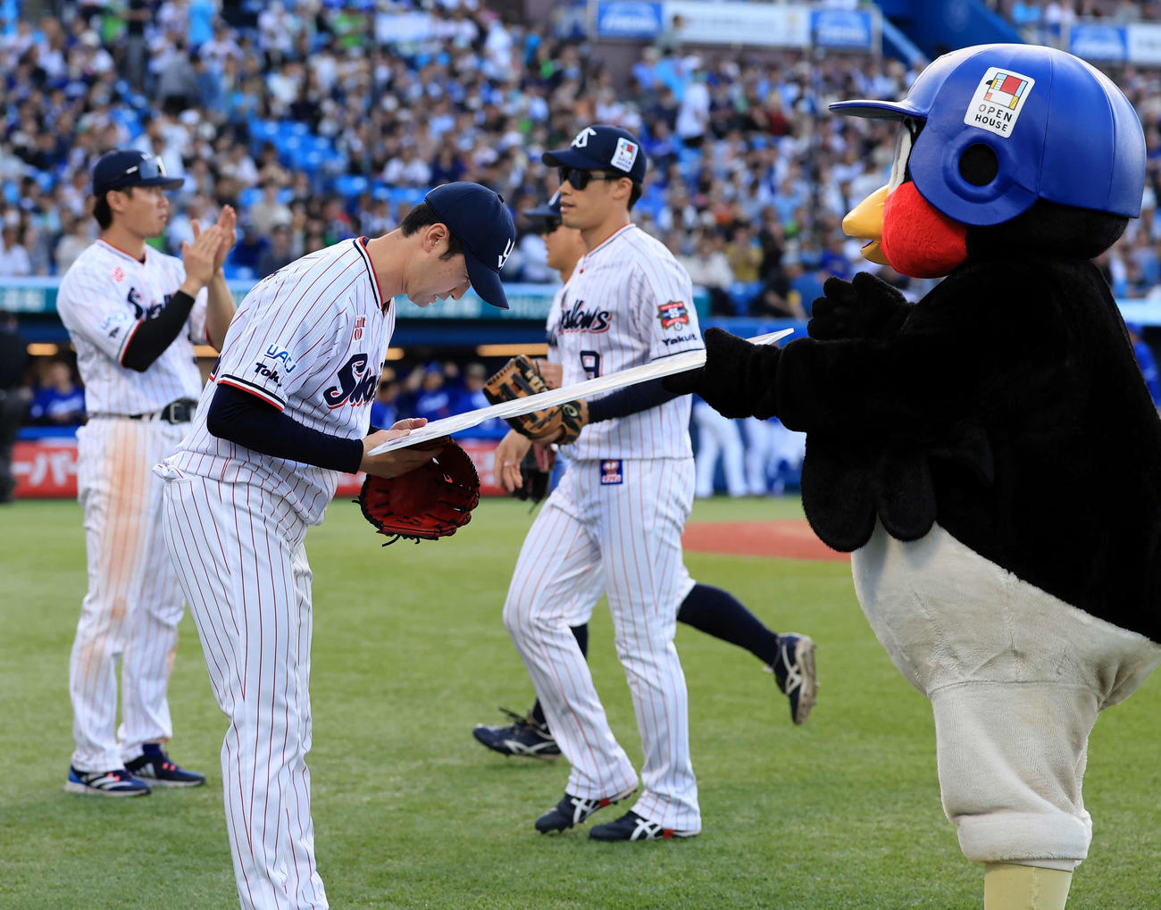 ヤクルト対中日　9回表中日の攻撃を抑えた石山は500試合登板を達成し、つば九郎からボードを受け取る（撮影・浅見桂子）