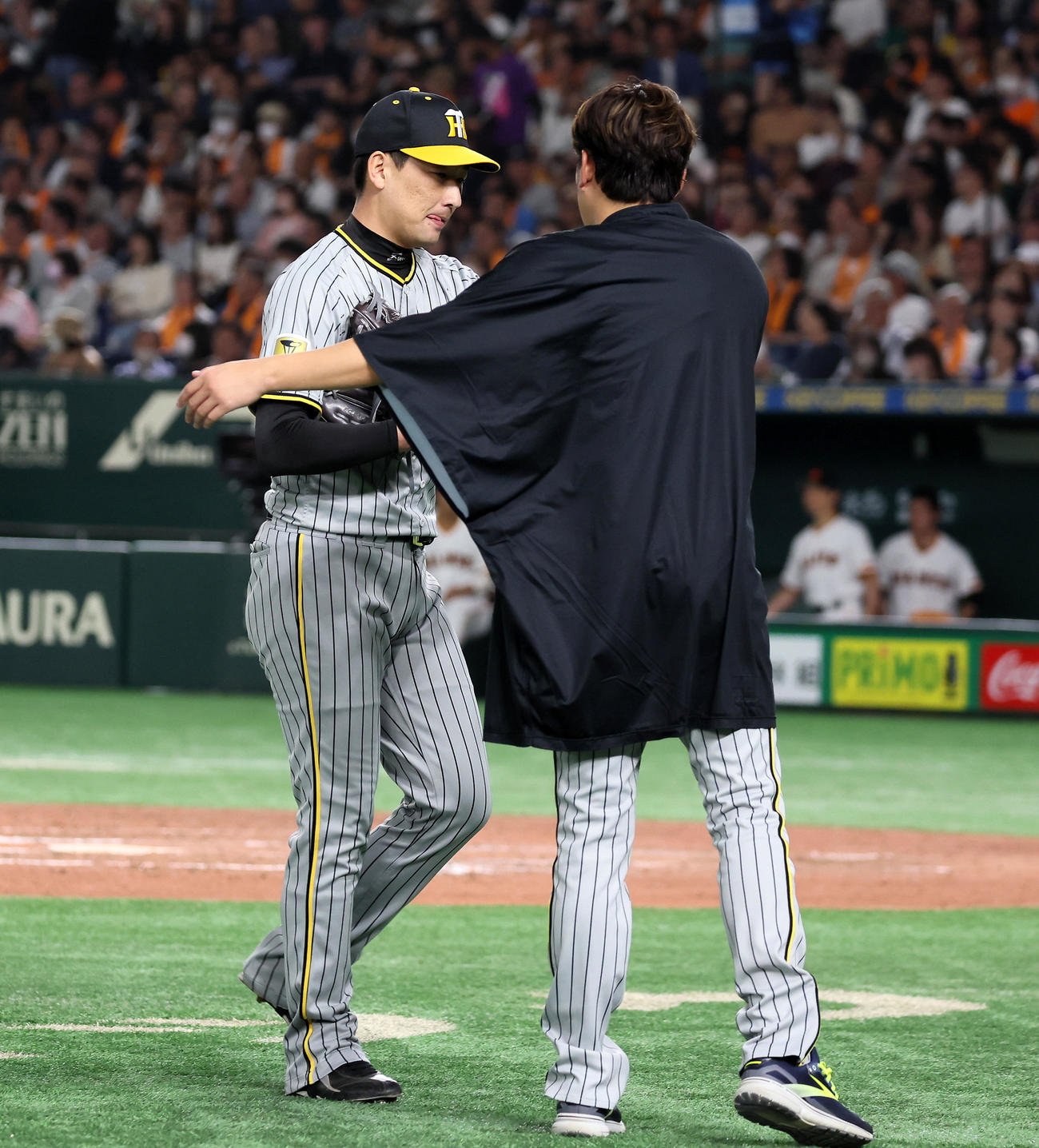 巨人対阪神　8回裏、失点した岩崎（左）をベンチ前で迎える先発の西勇（撮影・加藤哉）