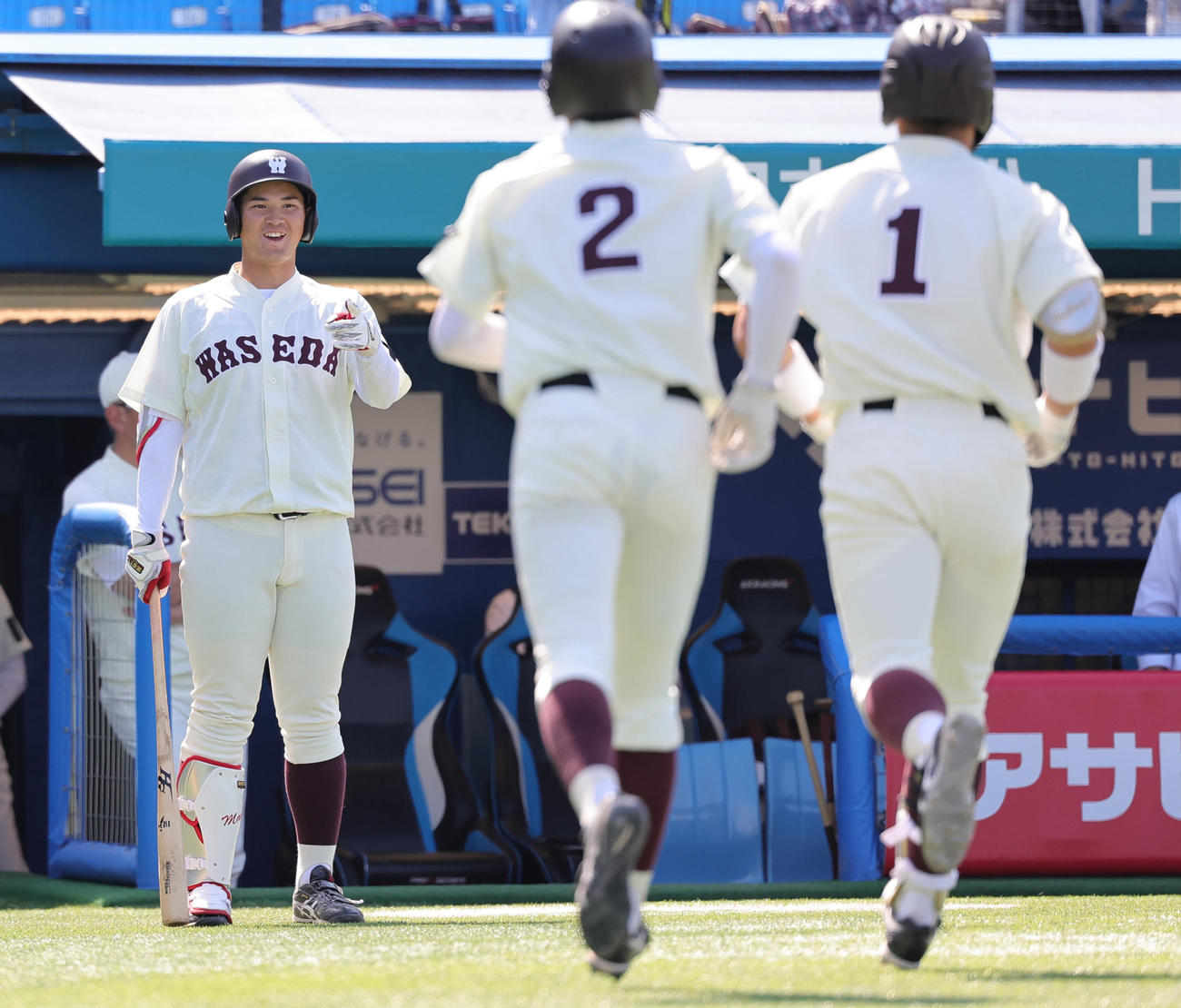 早大対東大　5回表早大2死一塁、右越え2点本塁打を放った吉納（右）らを迎える印出（撮影・野上伸悟）