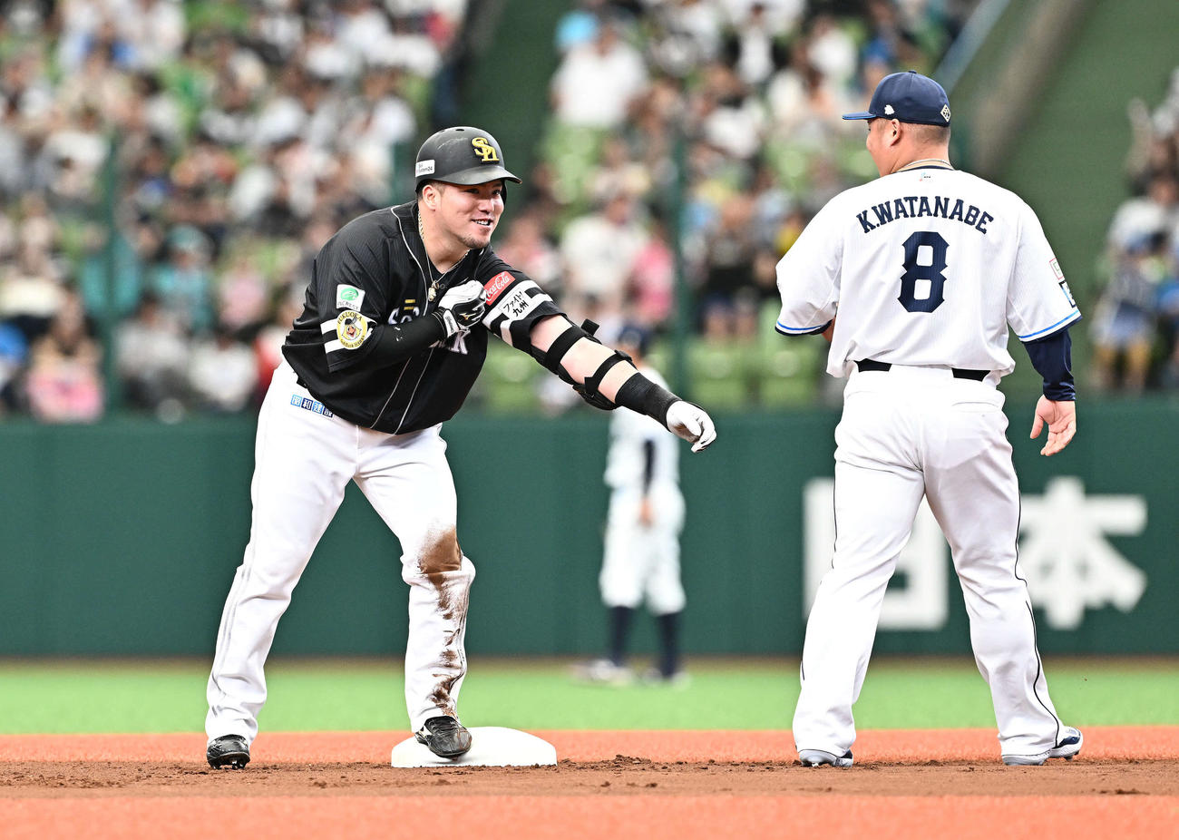 西武対ソフトバンク　1回表ソフトバンク2死一塁、先制適時二塁打を放った山川（左）は笑顔をみせる。一塁手渡部（撮影・滝沢徹郎）