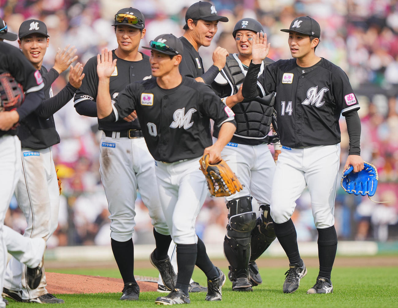 楽天対ロッテ　完投勝利のロッテ先発の小島（右）はナインとタッチを交わす（撮影・垰建太）