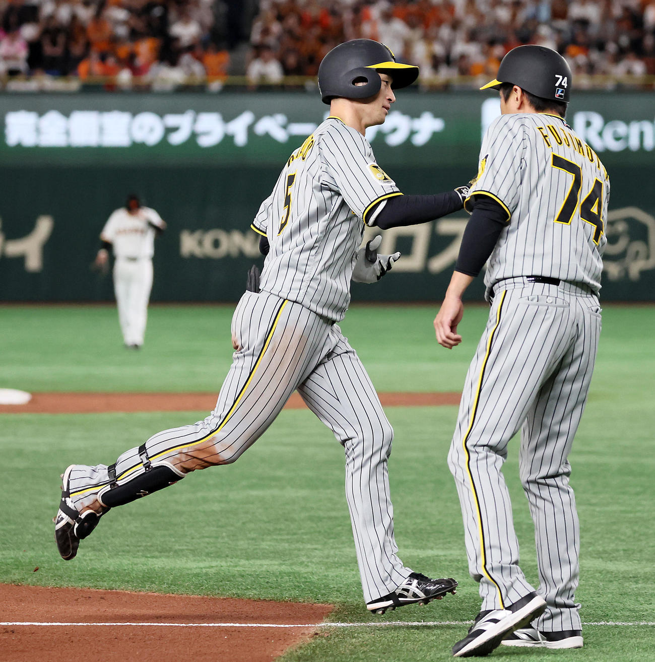 巨人対阪神　3回表阪神1死二塁、近本は右越え2点本塁打を放ち藤本コーチ（右）とタッチ（撮影・加藤哉）