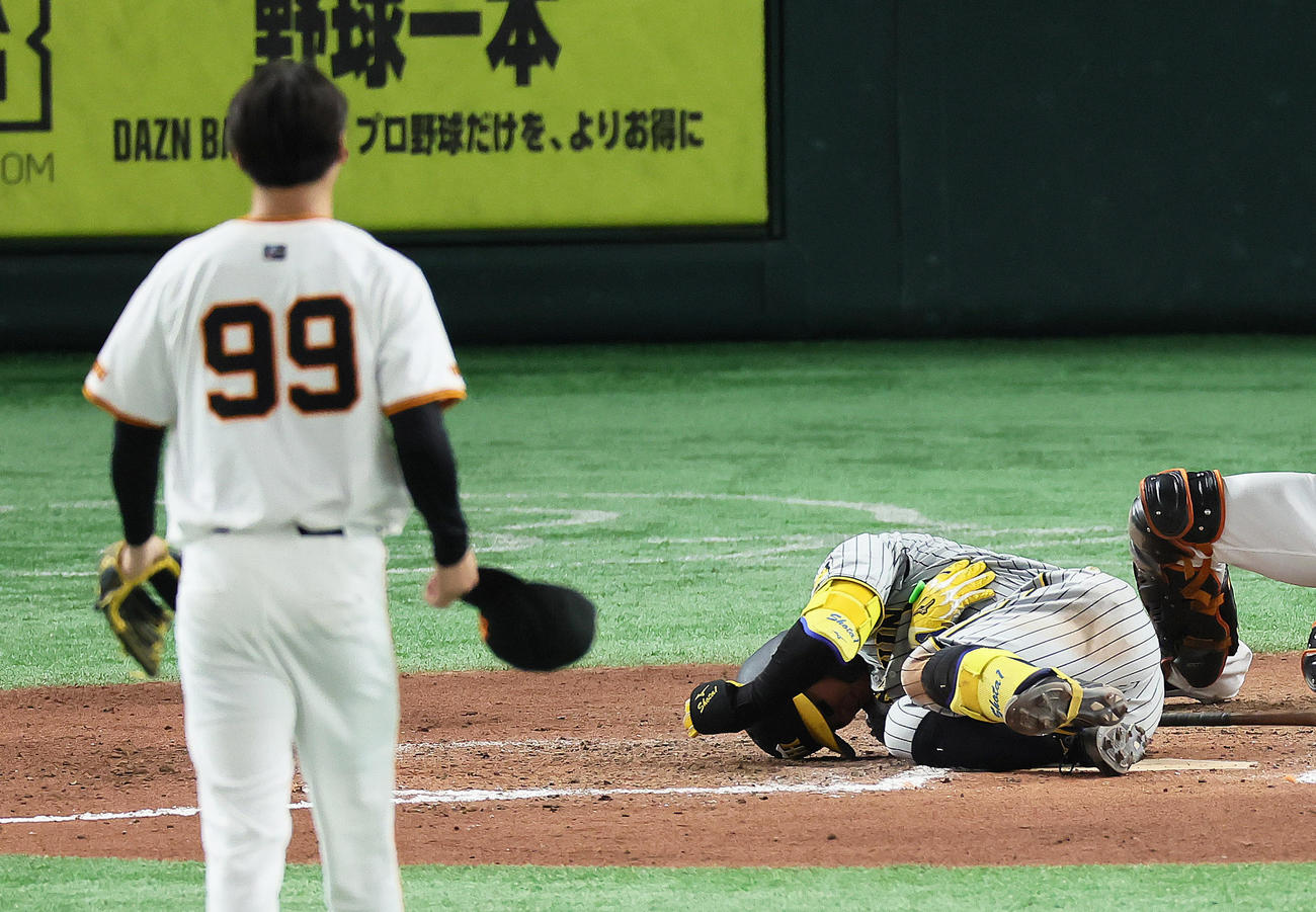 巨人対阪神　8回表阪神無死一塁、森下は死球を受け倒れ込む。投手京本（撮影・足立雅史）