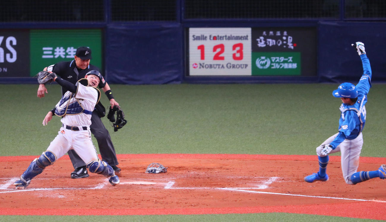 オリックス対日本ハム　8回表日本ハム1死一、三塁、中島は松本剛の投前セーフティースクイズで生還する。捕手は森（撮影・宮崎幸一）