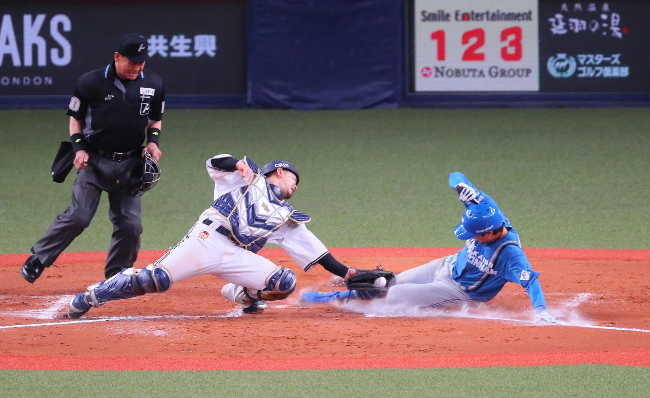 オリックス対日本ハム　8回表日本ハム1死一、三塁、中島は松本剛の投前セーフティースクイズで生還する。捕手は森（撮影・宮崎幸一）