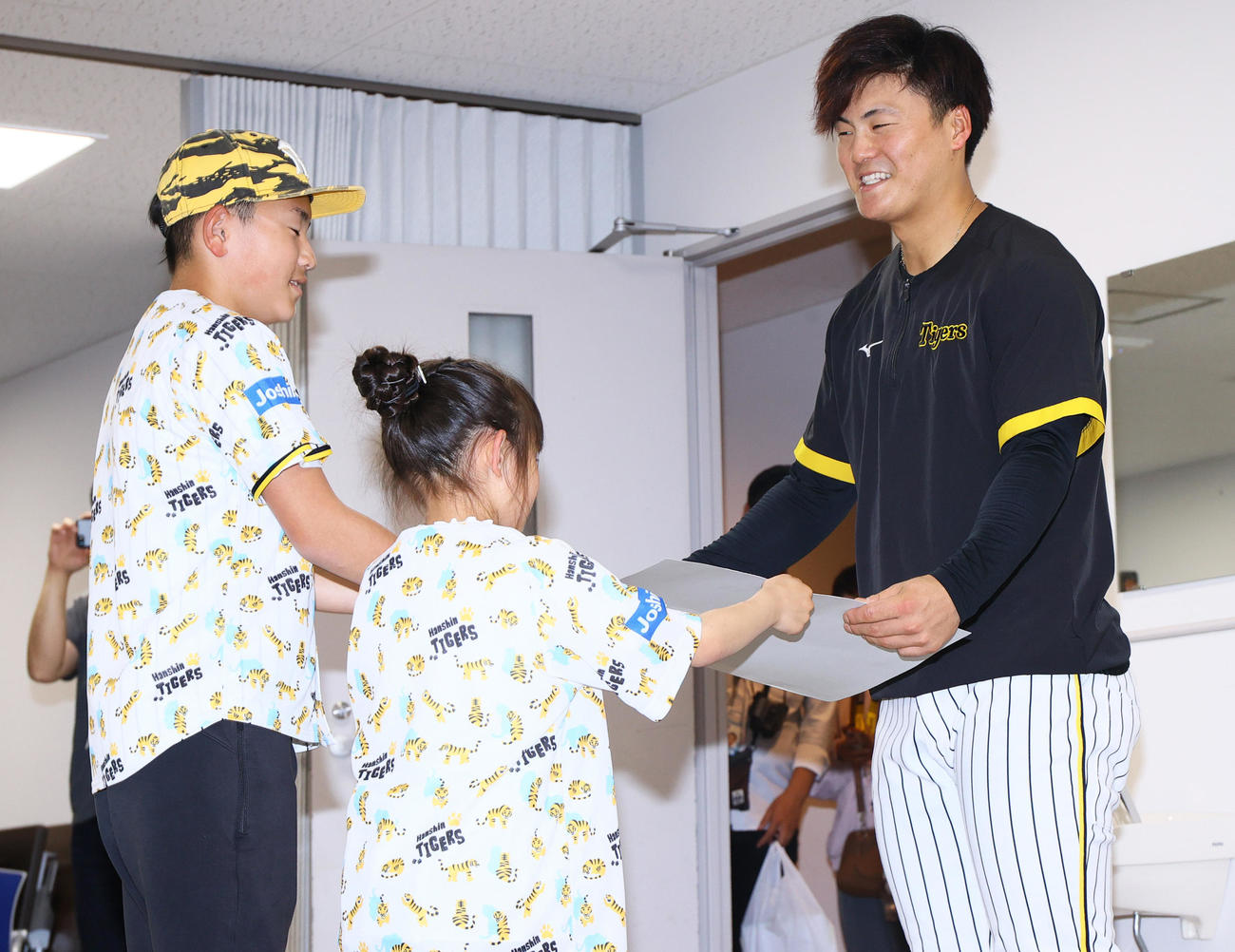 阪神前川（右）はファミリーデーに招待された子供から記念品が贈られる（撮影・上山淳一）