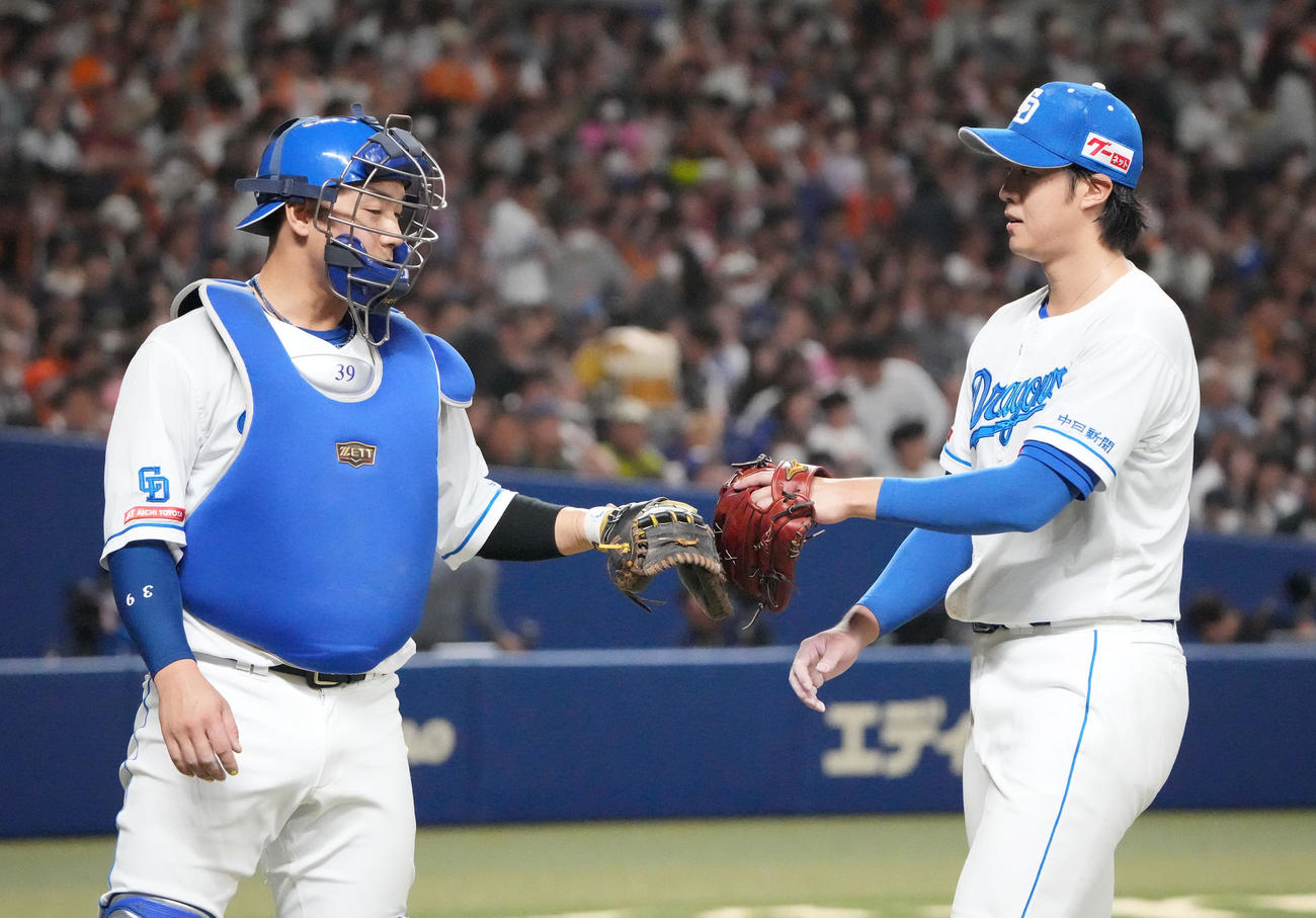 中日対巨人　2回表終了、宇佐見とタッチを交わしベンチへ戻る梅津（右）（撮影・森本幸一）