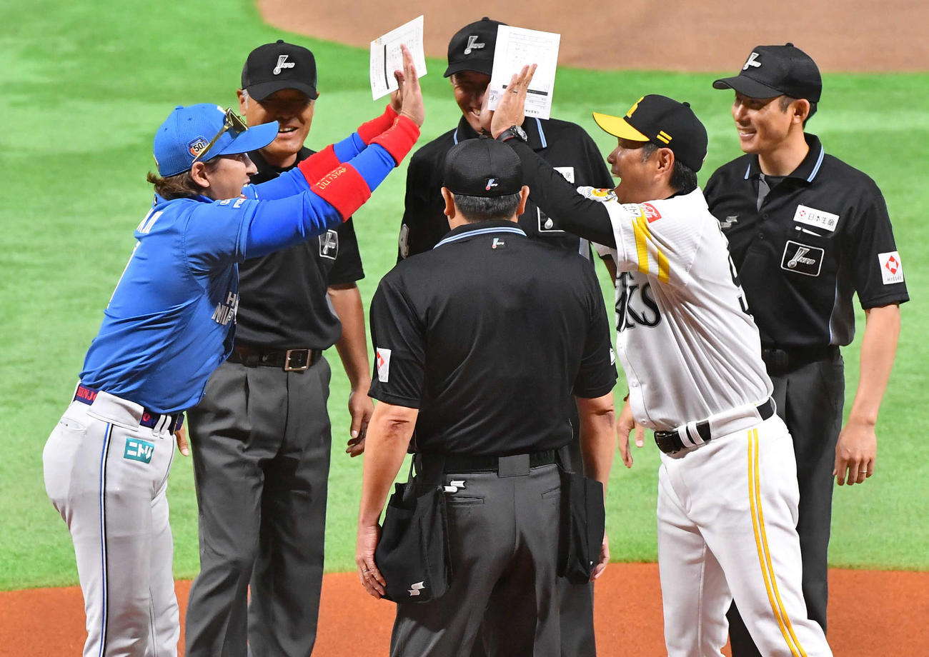 ソフトバンク対日本ハム　試合前、メンバー表交換で円陣を組み、笑顔でハイタッチする日本ハム新庄監督（左端）とソフトバンク小久保監督（右から2人目）（撮影・岩下翔太）