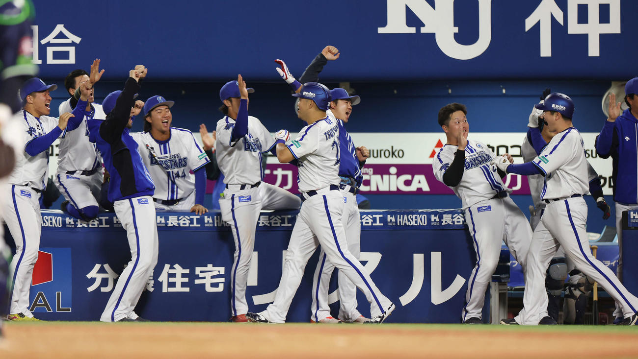 DeNA対ヤクルト　8回裏DeNA2死一、右中間へ逆転3点本塁打を放ち、笑顔でチームメートとタッチを交わす筒香（中央）（撮影・宮地輝）