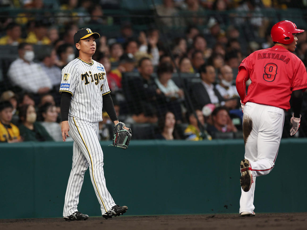 阪神対広島　1回表広島1死一、三塁、小園に犠飛を浴び先生を許した村上。右は生還した秋山（撮影・前田充）