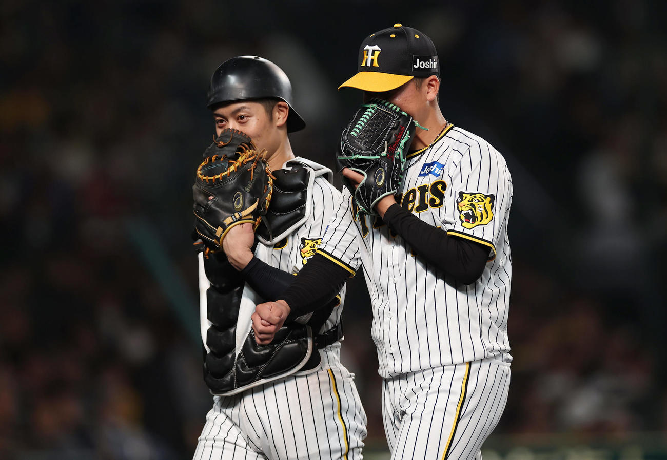 阪神対広島　5回表を投げ終え、阪神坂本（左）と言葉を交わしながらベンチへ戻る村上（撮影・前田充）