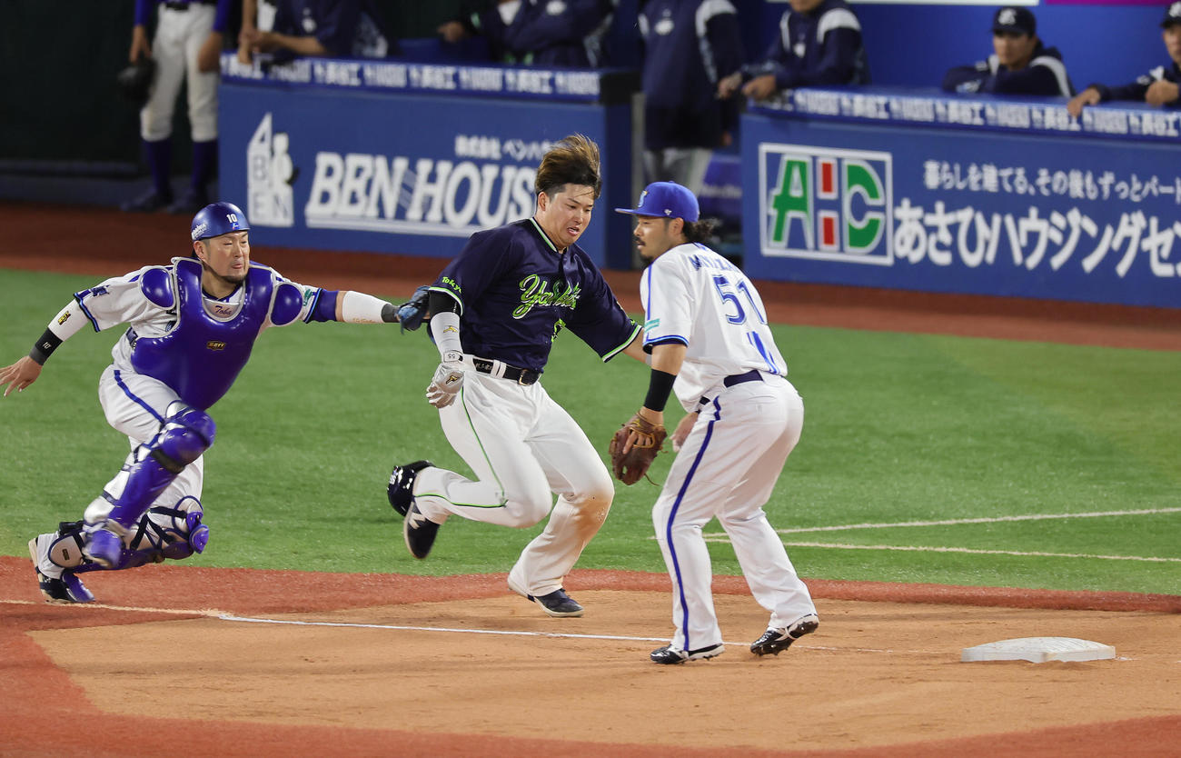DeNA対ヤクルト　1回表ヤクルト1死一、三塁、中村のスクイズで本塁を狙うも三塁アウトとなる三塁走者村上（中央）。捕手戸柱（撮影・足立雅史）