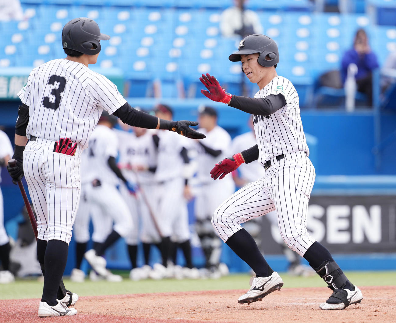 亜大対駒大　9回表亜大無死、右越えソロ本塁打を放ち生還する西川（右）（撮影・鈴木みどり）