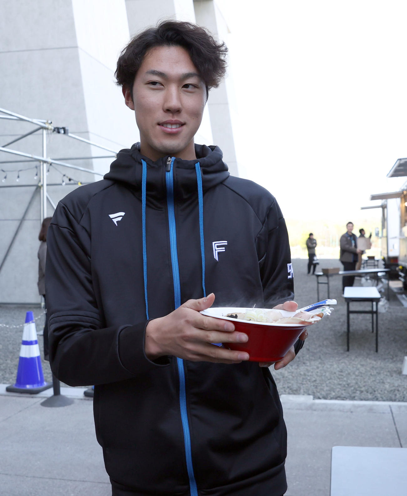 「七つ星横丁裏路地ラーメンテラス」のお披露目会でラーメンを運ぶ日本ハム福島（撮影・佐藤翔太）