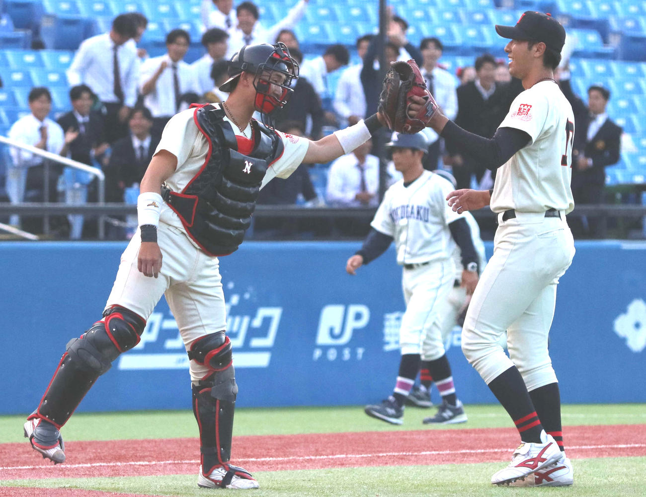 日大対国学院大　1失点完投勝利を飾りグラブタッチする日大・市川（右）と南條のバッテリー（撮影・塚本光）