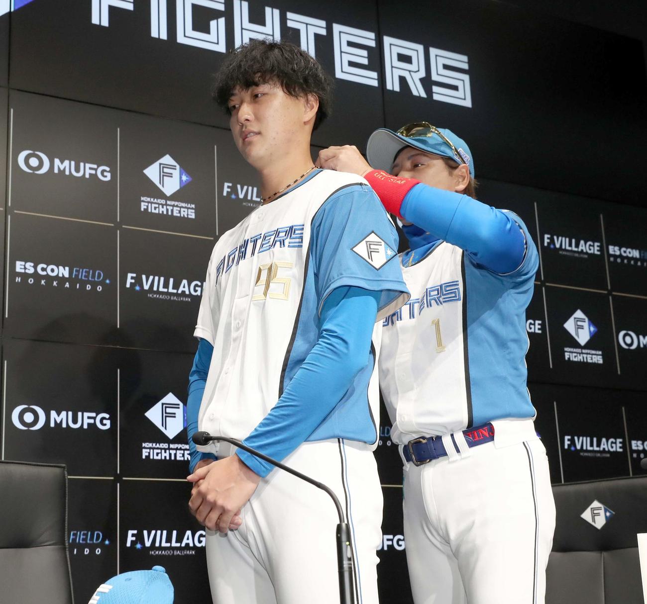 日本ハム対ロッテ　支配下登録された日本ハム柳川（左）にネックレスを贈る新庄監督（撮影・黒川智章）