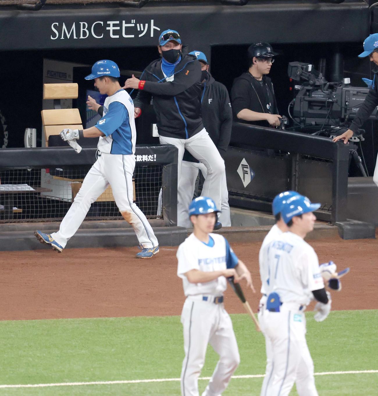 日本ハム対ロッテ　6回裏日本ハム2死二、三塁、松本剛（手前）の2点適時打で生還した水野を出迎える新庄監督（撮影・黒川智章）