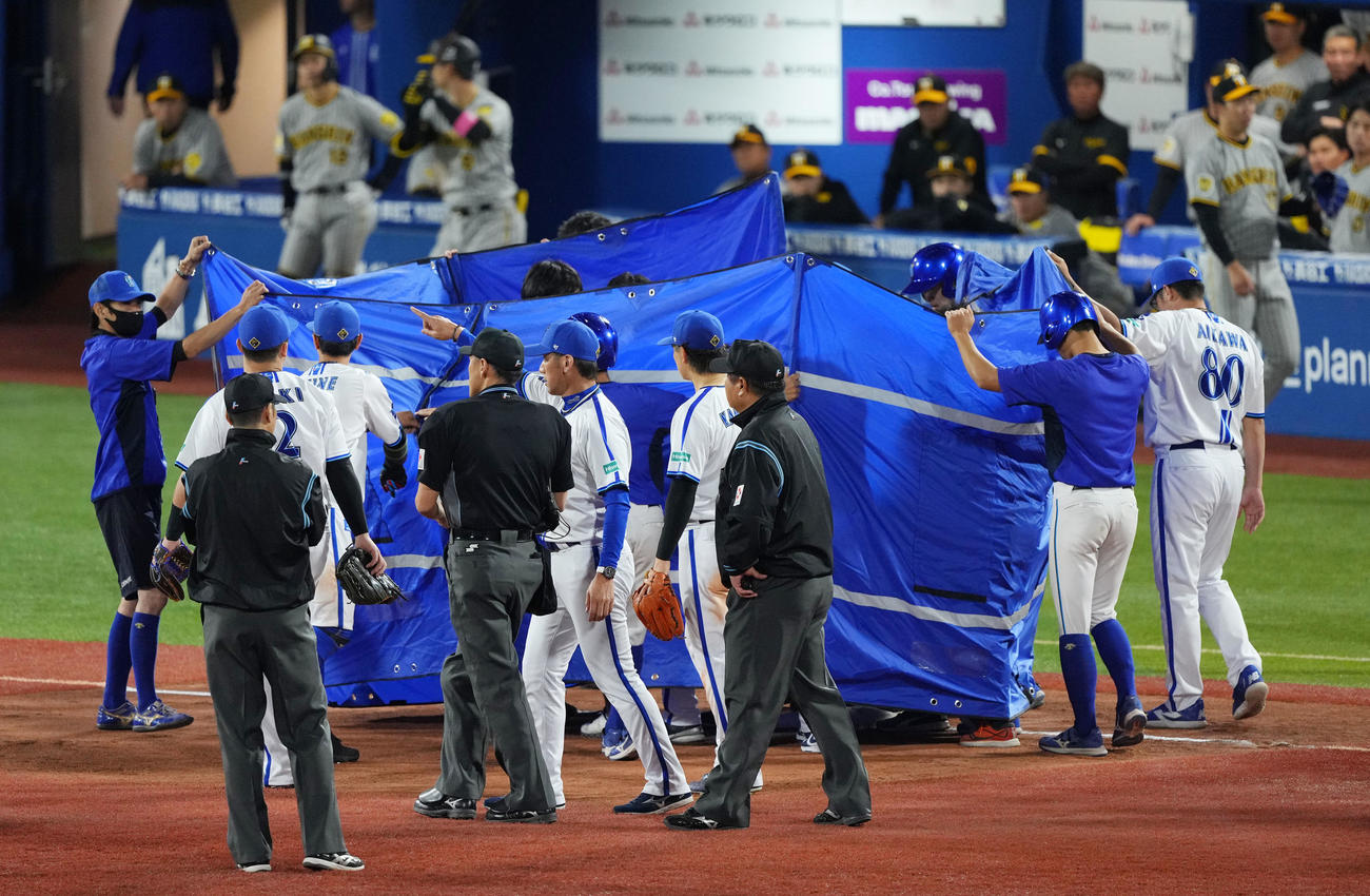 DeNA対阪神　6回表途中、シートに囲まれながらグラウンドを後にするするDeNA宮崎（撮影・横山健太）