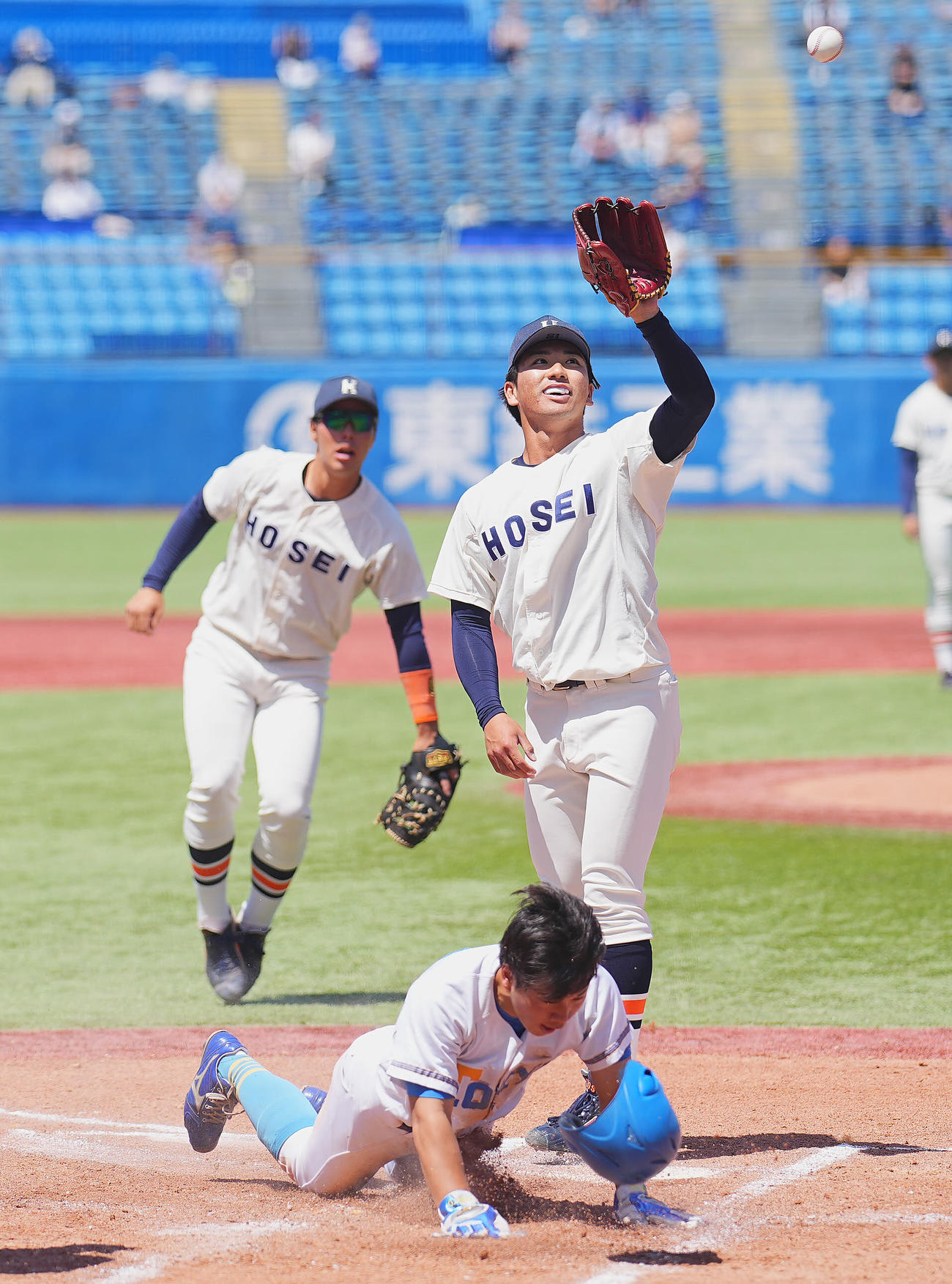 法大対東大　1回裏東大1死二、三塁、打者大原の時、捕逸で三走榎本（下）に先制の生還を許す篠木（右）（撮影・垰建太）
