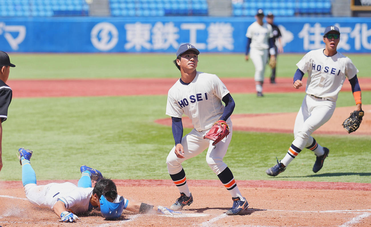 法大対東大　1回裏東大1死二、三塁、打者大原の時、捕逸で三走榎本（左）に先制の生還を許す篠木（中央）（撮影・垰建太）