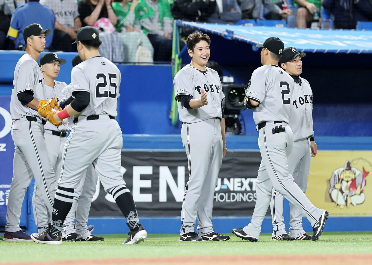 ヤクルト対巨人　7回裏、ヤクルトの攻撃を抑えた選手たちを笑顔で迎える巨人菅野（中央）（撮影・鈴木正人）