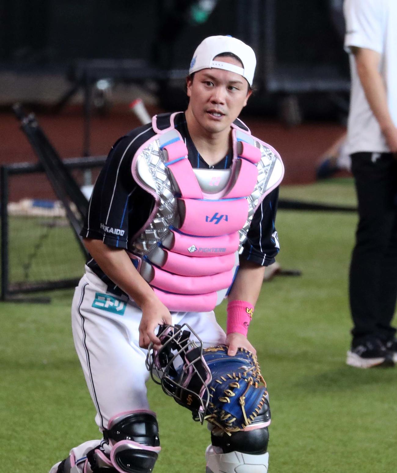 日本ハム対ロッテ　母の日でピンクのプロテクターをつけ練習する伏見（撮影・黒川智章）