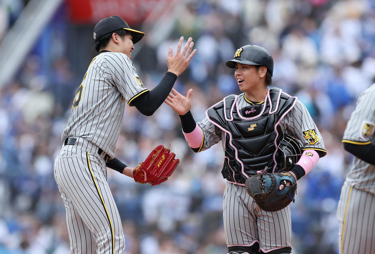 DeNA対阪神　DeNAに完封勝利を飾り、握手を交わす阪神才木（左）と梅野（撮影・前田充）