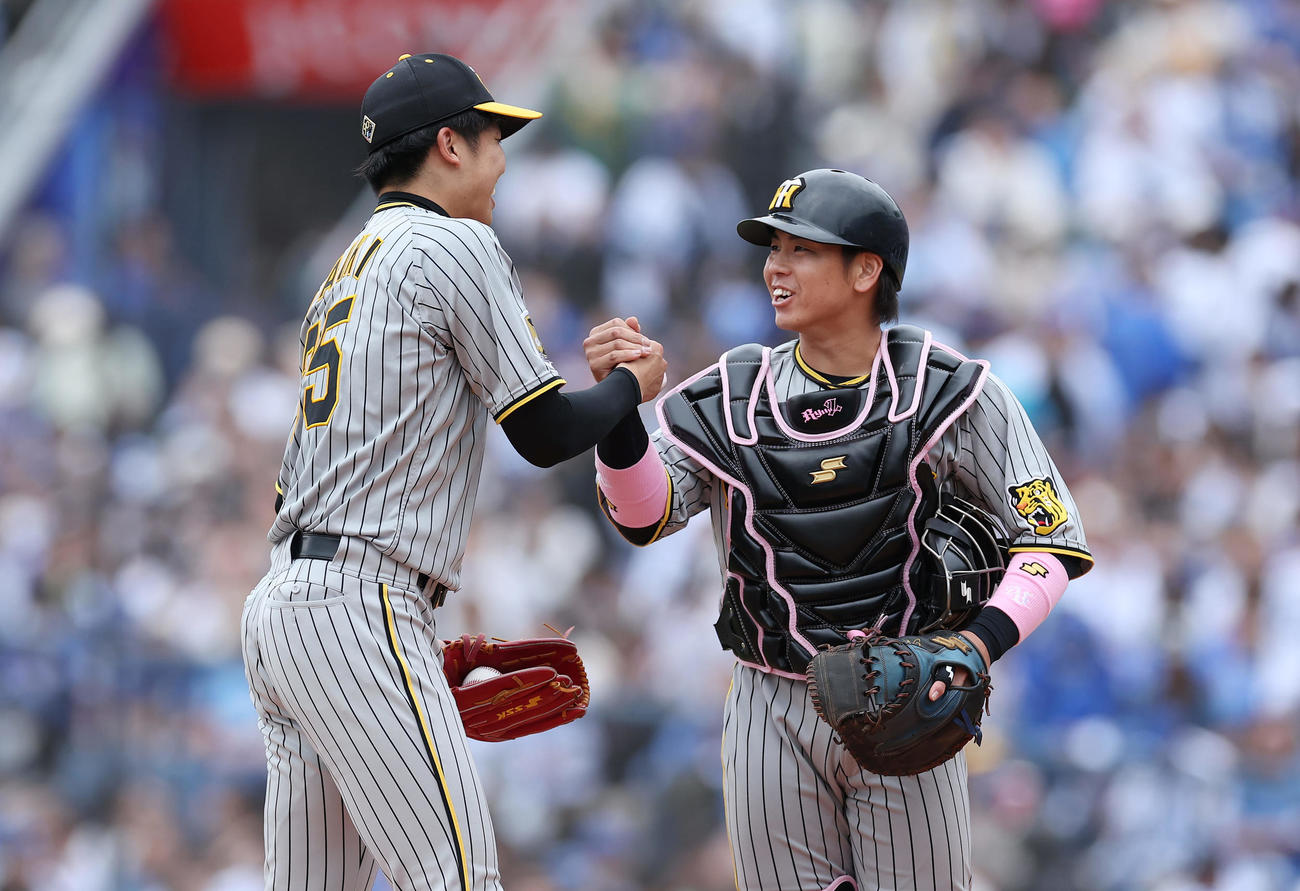 DeNA対阪神　DeNAに完封勝利を飾り、握手を交わす阪神才木（左）と梅野（撮影・前田充）