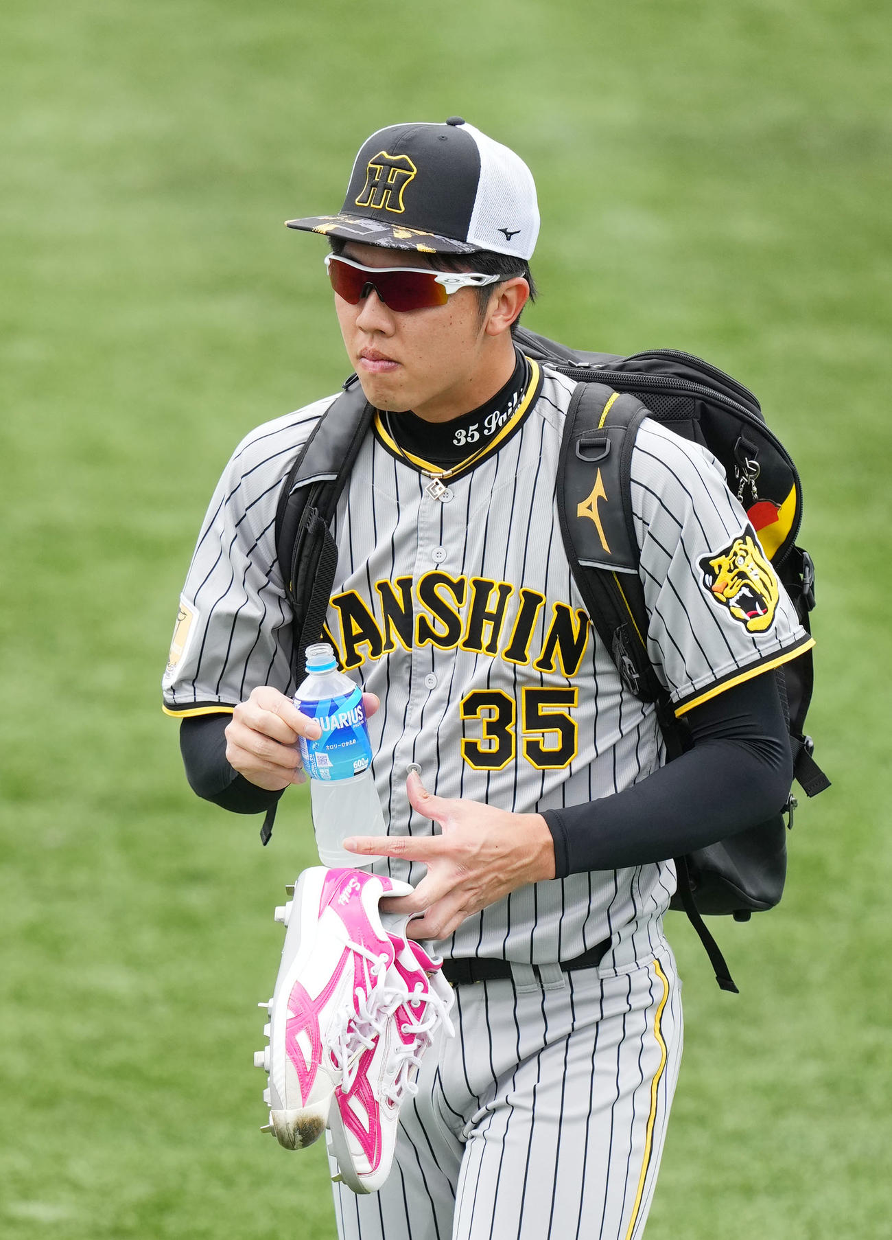 DeNA対阪神　母の日に合わせピンクのスパイクを持って練習へ向かう阪神才木（撮影・横山健太）